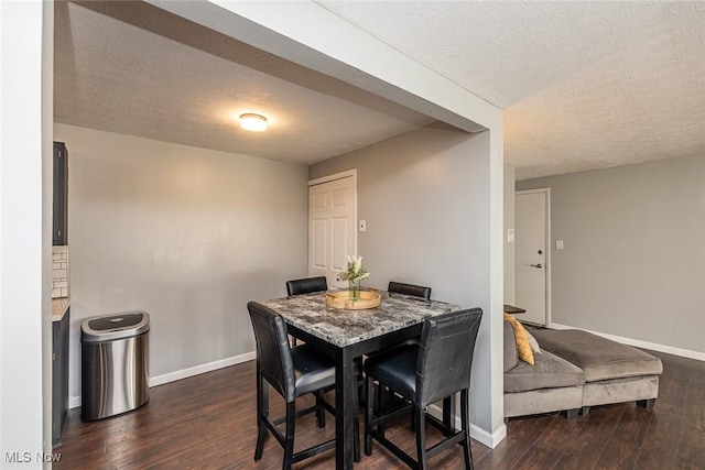 dining area featuring a textured ceiling and dark wood-type flooring