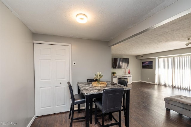 dining room with a textured ceiling and dark wood-type flooring