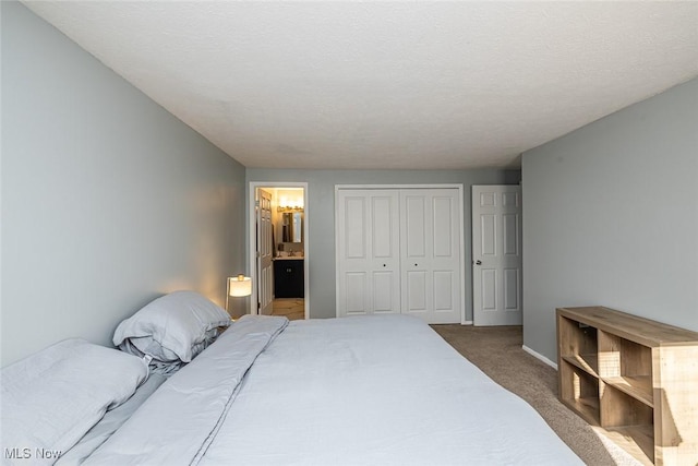 bedroom with ensuite bath, a closet, and carpet flooring