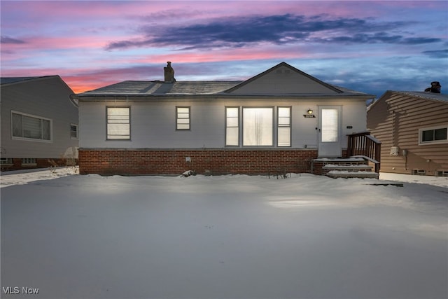 view of snow covered rear of property