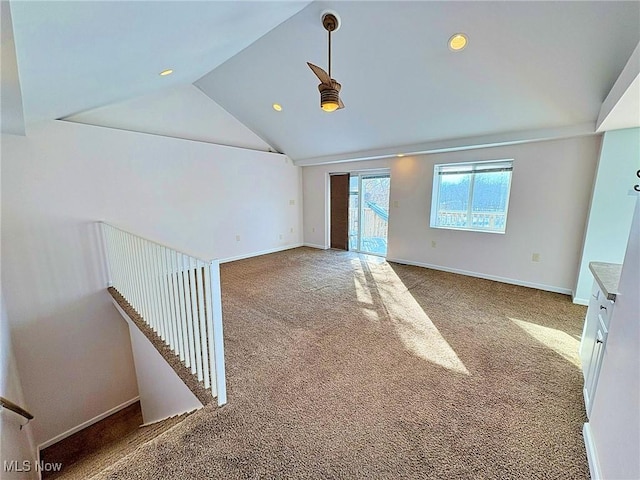 spare room featuring carpet flooring and vaulted ceiling