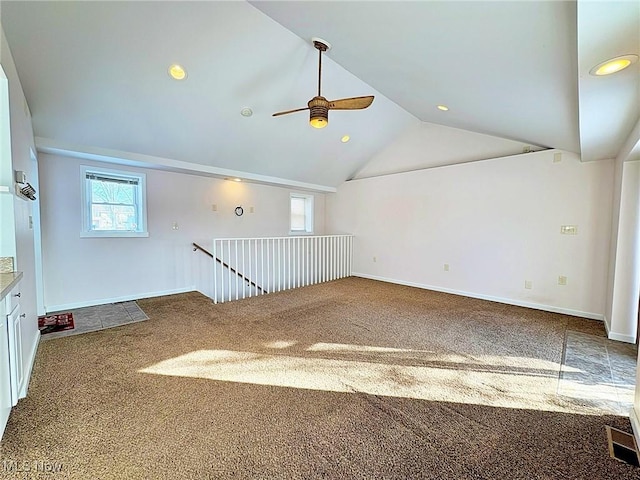 spare room with vaulted ceiling, carpet floors, and ceiling fan