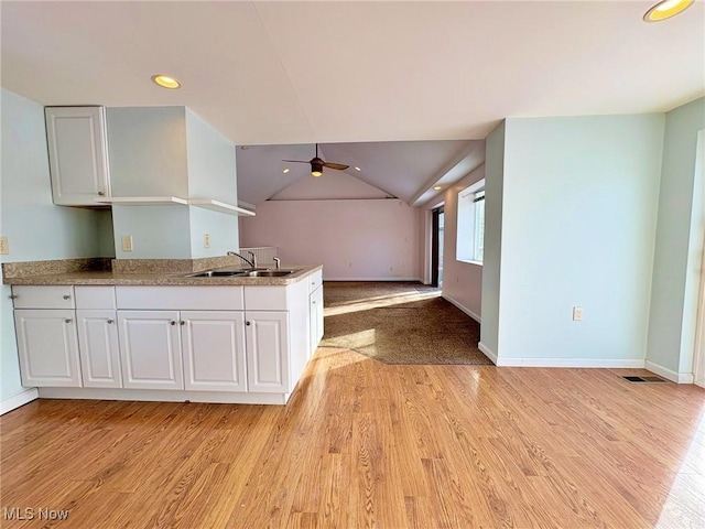 kitchen featuring sink, white cabinetry, ceiling fan, and light hardwood / wood-style flooring