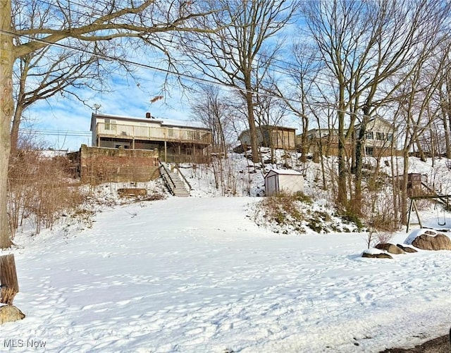 yard covered in snow with a deck