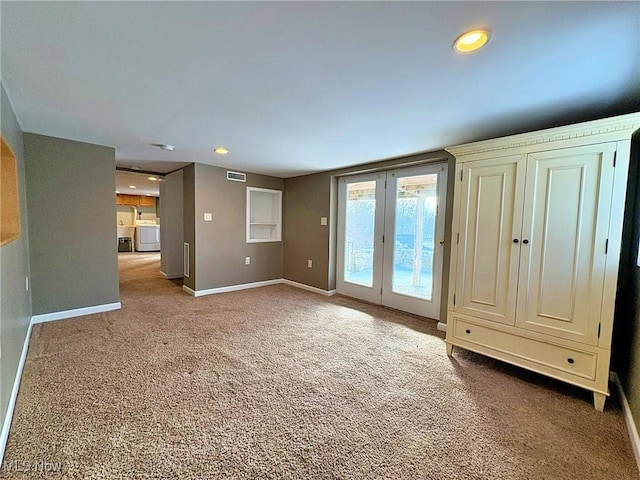 interior space featuring french doors, washing machine and clothes dryer, and carpet