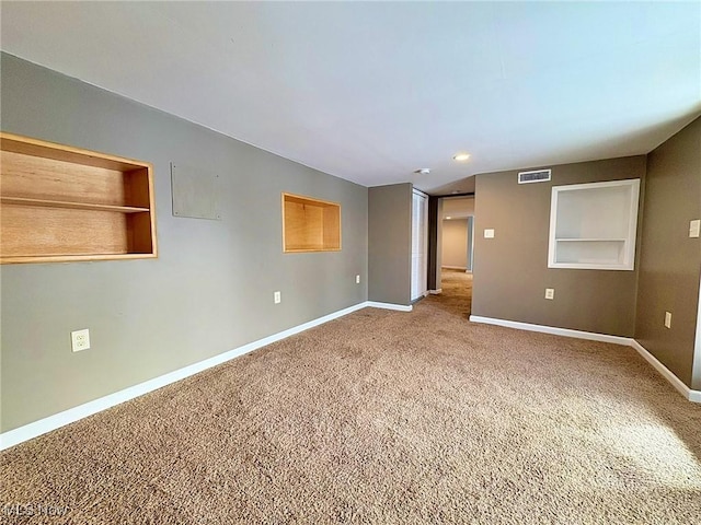 unfurnished room with built in shelves and carpet flooring