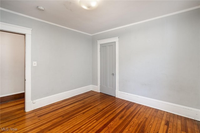 spare room featuring crown molding and wood-type flooring