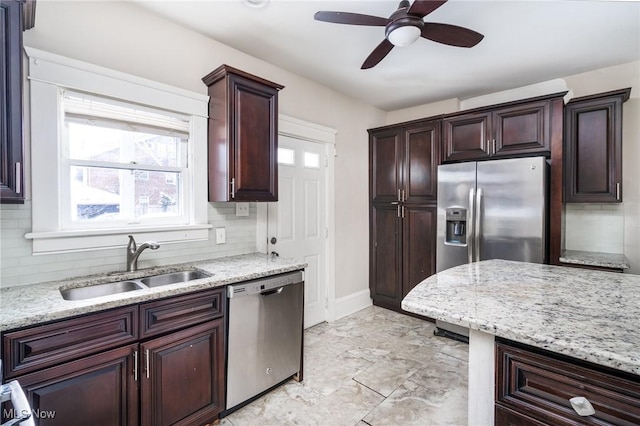 kitchen featuring sink, light stone counters, ceiling fan, backsplash, and appliances with stainless steel finishes