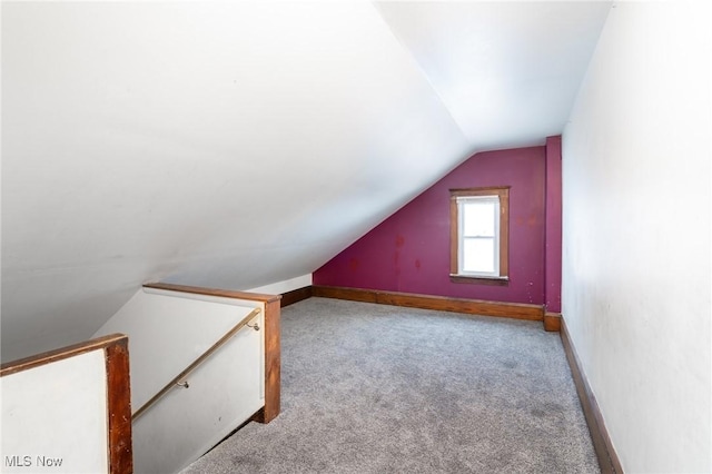 bonus room with vaulted ceiling and light carpet