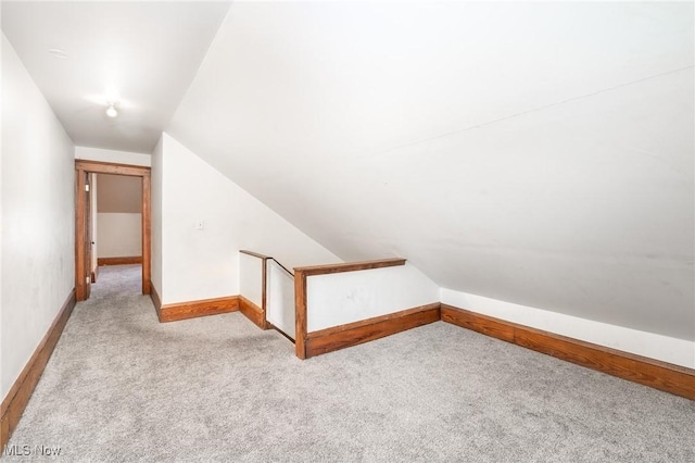 additional living space featuring light carpet and lofted ceiling