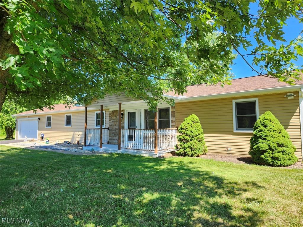 single story home featuring a porch and a front lawn