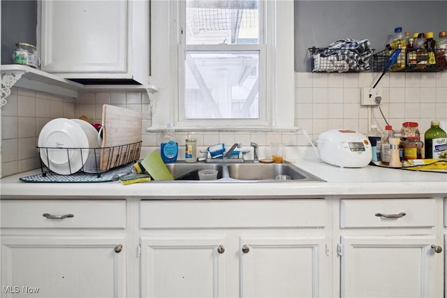 kitchen with sink, white cabinetry, and tasteful backsplash