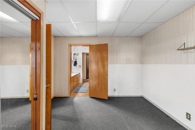 carpeted empty room featuring a paneled ceiling