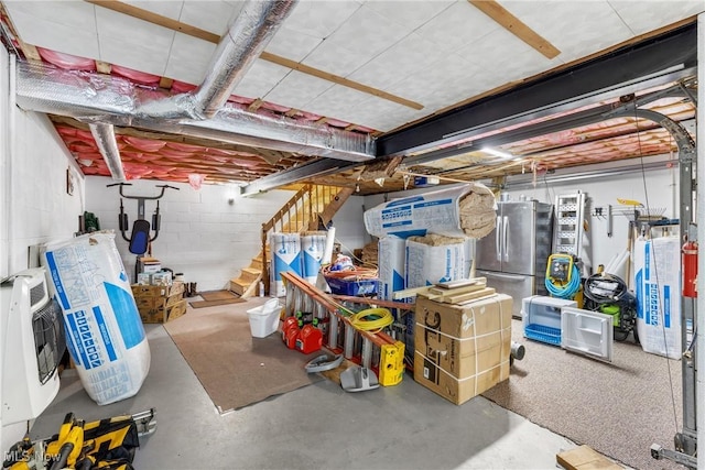 basement featuring heating unit and stainless steel fridge