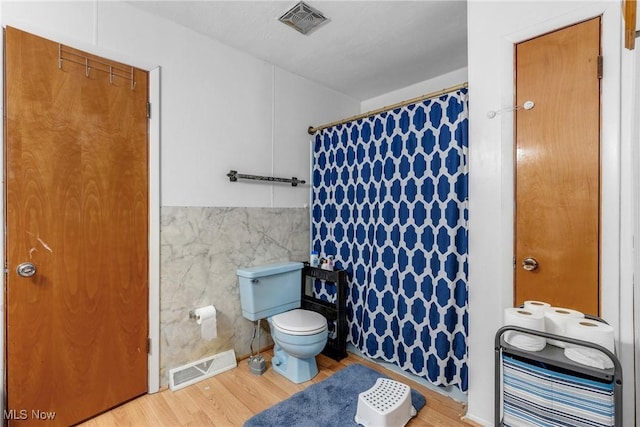 bathroom with toilet, tile walls, hardwood / wood-style floors, and a textured ceiling