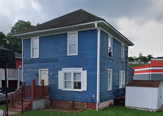 view of front of property featuring a front yard and a storage unit