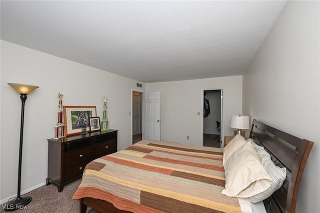 carpeted bedroom with a closet and a spacious closet