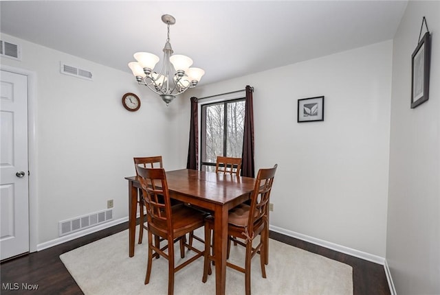 dining area with an inviting chandelier and dark hardwood / wood-style floors