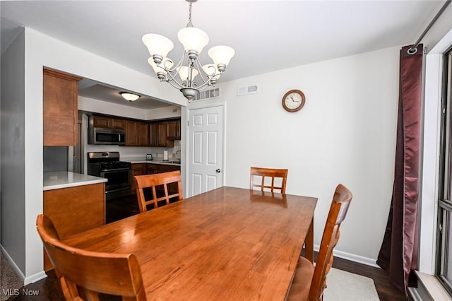 dining room with a notable chandelier, dark hardwood / wood-style flooring, and sink