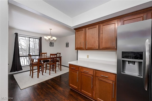 kitchen featuring stainless steel refrigerator with ice dispenser, a notable chandelier, hanging light fixtures, and dark hardwood / wood-style floors