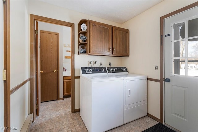 laundry area with cabinets and washing machine and clothes dryer