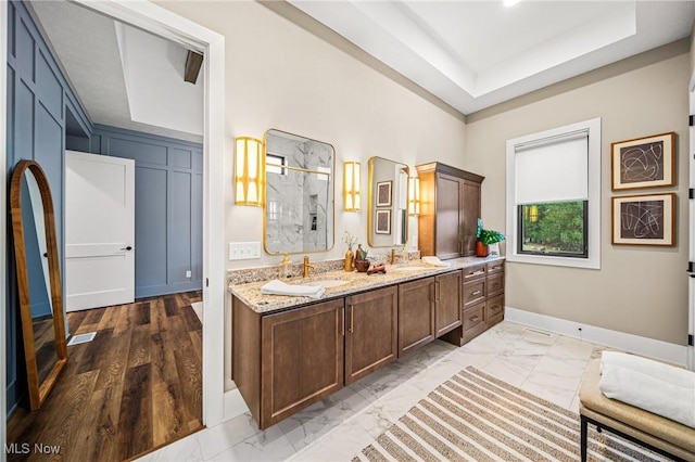 bathroom with vanity, a raised ceiling, and a shower