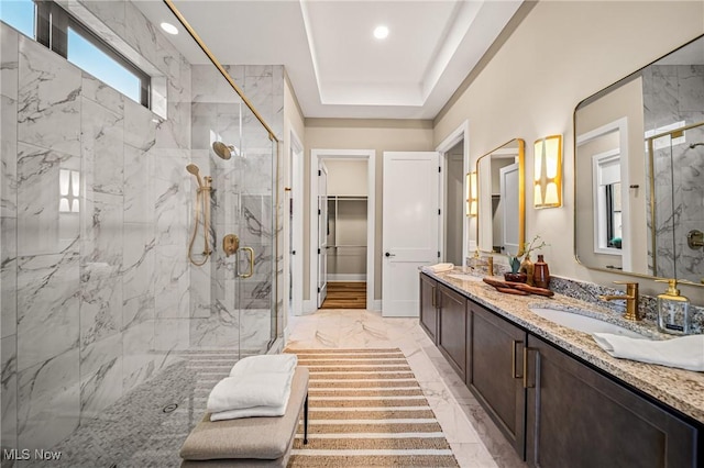 bathroom featuring an enclosed shower, a tray ceiling, and vanity