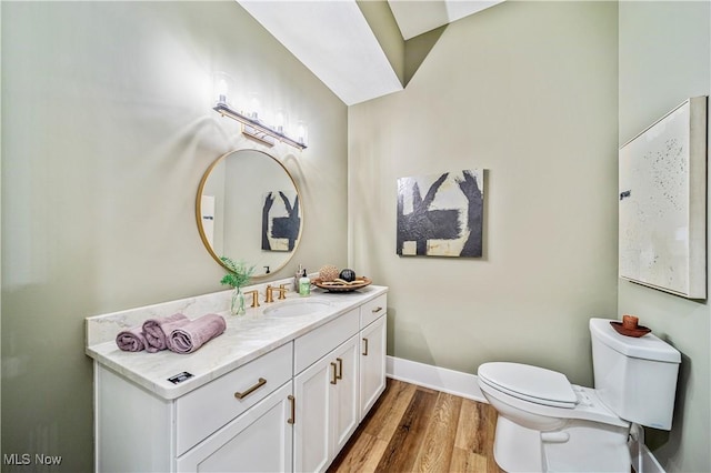 bathroom with toilet, wood-type flooring, and vanity