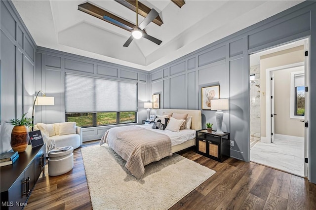 bedroom featuring ceiling fan, dark wood-type flooring, lofted ceiling, and a tray ceiling