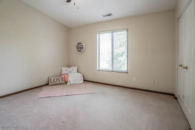 unfurnished bedroom with a closet, ceiling fan, and light colored carpet