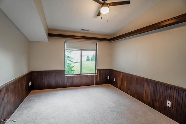 carpeted spare room with ceiling fan and vaulted ceiling