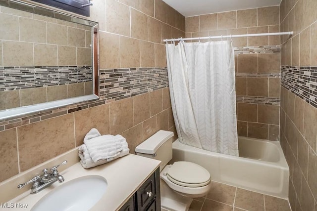 full bathroom featuring toilet, shower / bath combo with shower curtain, tile walls, and vanity