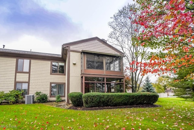 back of property featuring a yard, central AC unit, and a sunroom