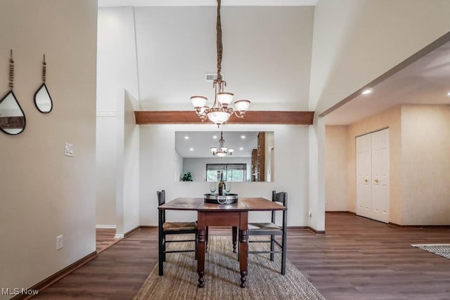 dining room featuring a towering ceiling, an inviting chandelier, and dark hardwood / wood-style floors