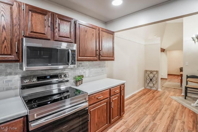 kitchen featuring stainless steel appliances, light hardwood / wood-style flooring, and decorative backsplash