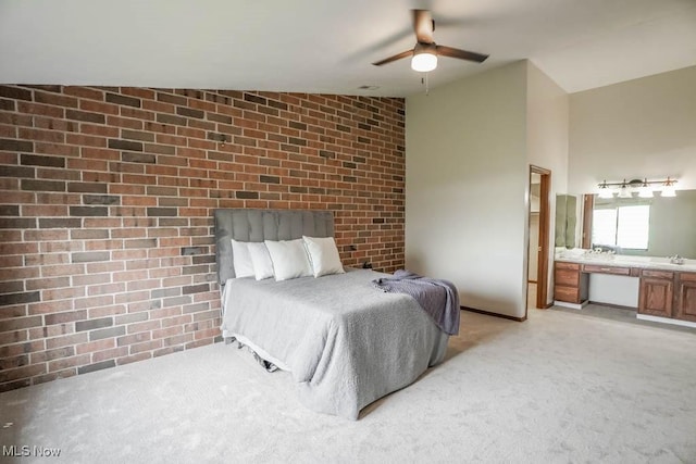 carpeted bedroom featuring lofted ceiling, sink, ceiling fan, and brick wall