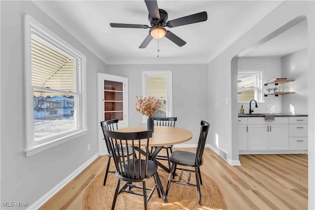 dining space featuring sink, ceiling fan, and light hardwood / wood-style flooring