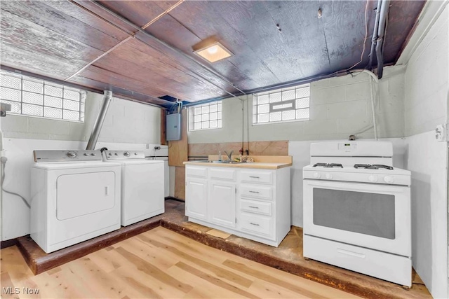 washroom with light wood-type flooring, washing machine and dryer, and sink