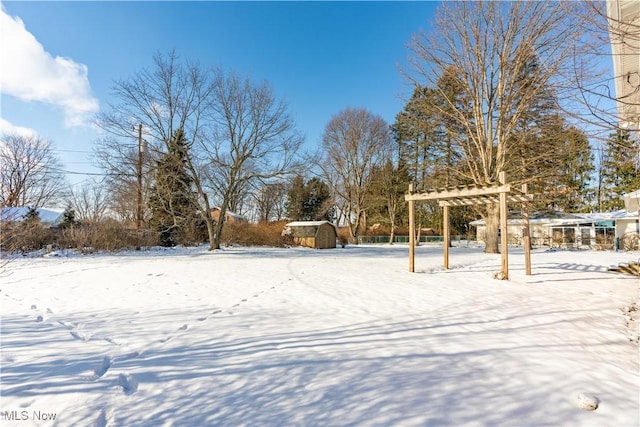 yard layered in snow with a pergola