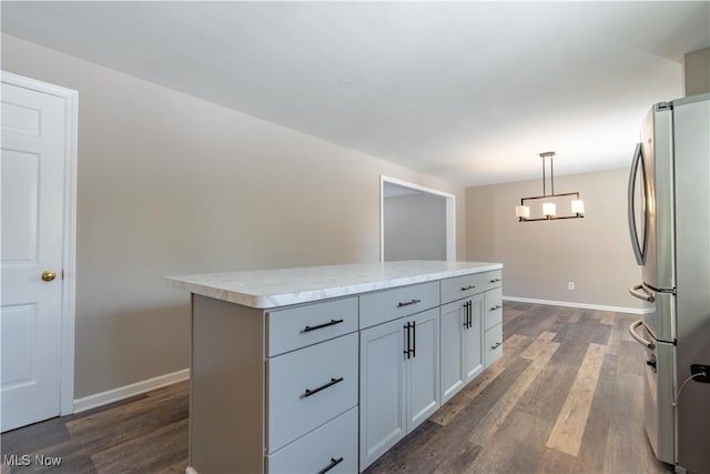 kitchen featuring dark wood-type flooring, decorative light fixtures, a kitchen island, and stainless steel refrigerator