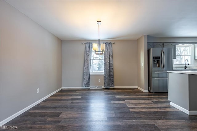 unfurnished dining area featuring sink and dark wood-type flooring