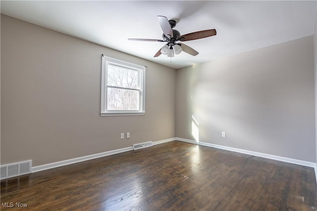 spare room featuring ceiling fan and dark hardwood / wood-style floors