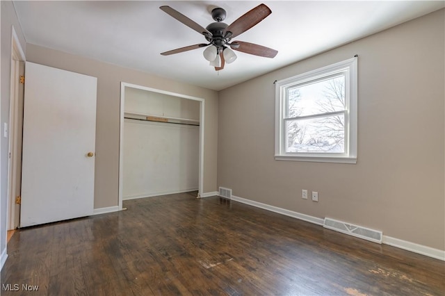 unfurnished bedroom with dark wood-type flooring, ceiling fan, and a closet