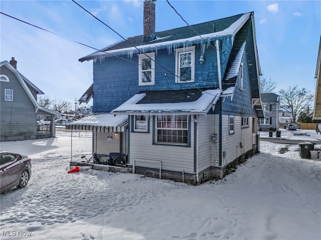 view of snow covered rear of property