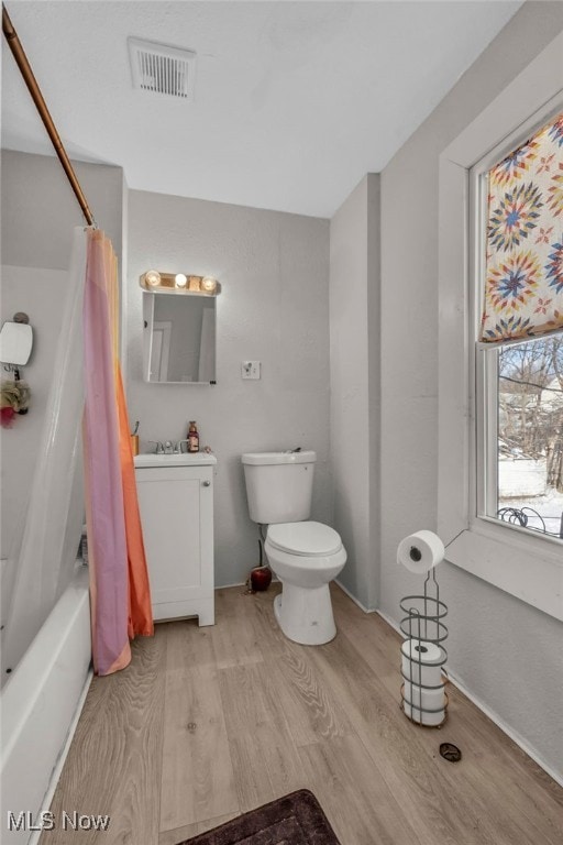 full bathroom featuring vanity, toilet, shower / bath combo with shower curtain, and hardwood / wood-style flooring