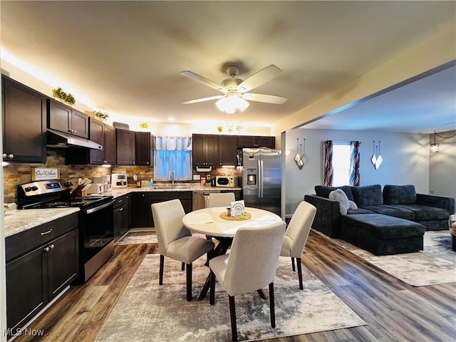 dining space featuring ceiling fan, sink, and hardwood / wood-style flooring