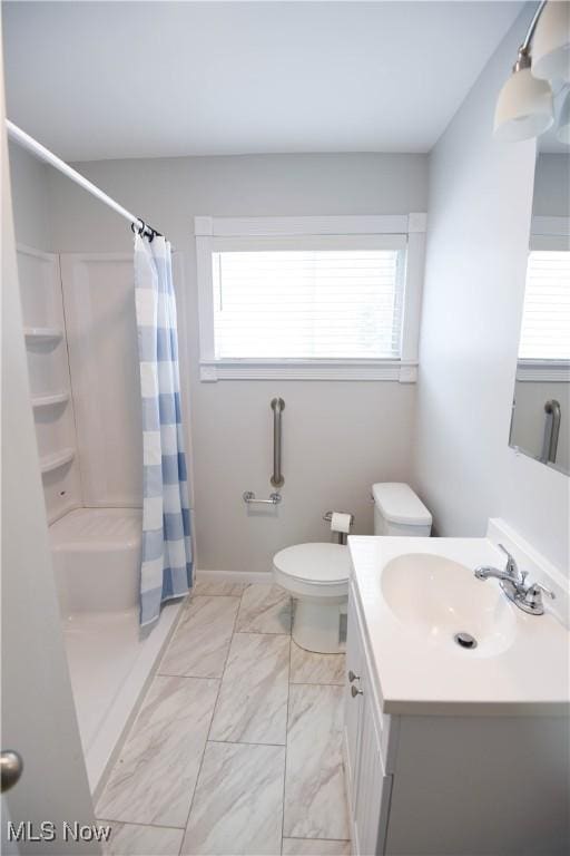 bathroom with vanity, toilet, a wealth of natural light, and walk in shower