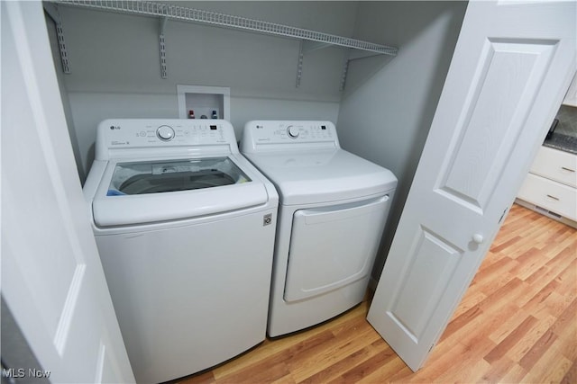 washroom featuring light hardwood / wood-style floors and washing machine and clothes dryer