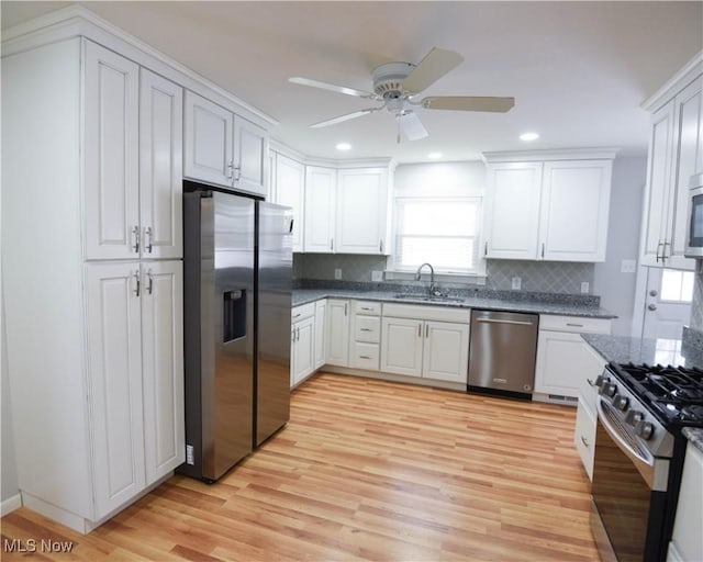 kitchen with ceiling fan, stainless steel appliances, white cabinetry, and sink