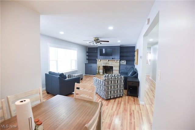 living room featuring ceiling fan, a fireplace, and hardwood / wood-style floors